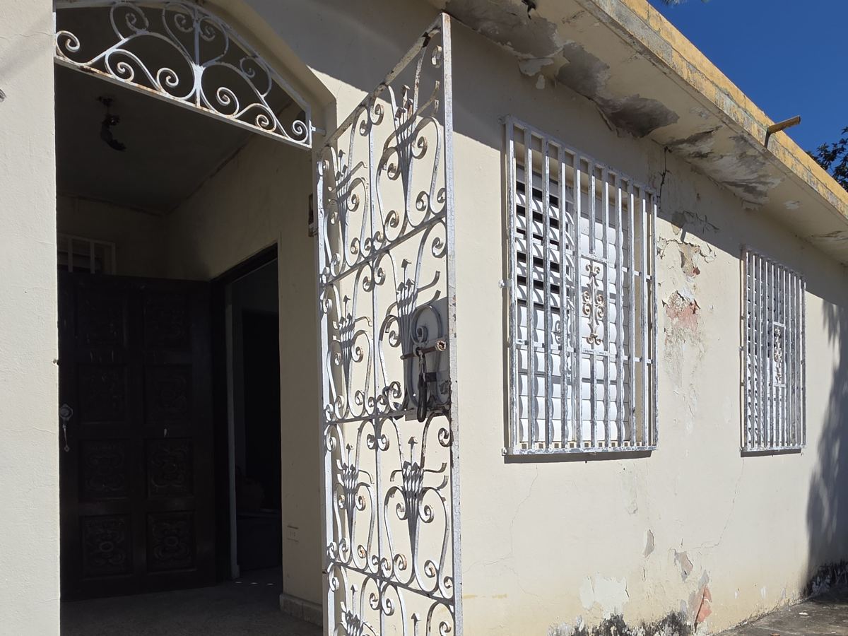 Fachada de la casa en Río Piedras antes de la restauración: pintura descascarada y rejas oxidadas